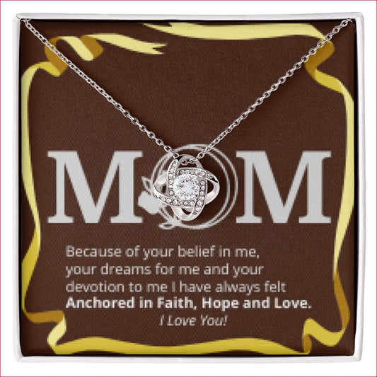 MOM Faith Hope and Love CZ Love Knot Pendant is gift boxed. Presented lying over inlaid sentimental message card greeting, which reads:  "Mom. Because of your belief in me, your dreams for me and your devotion to me I have always felt Anchored in Faith, Hope and Love. I Love You!" Encircled with golden ribbon drawing.