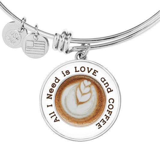 Love Coffee Charm says "All I Need is Love and Coffee" around a photo of coffee art depicting 3 hearts coming out of the coffee froth, on a wire style bangle.