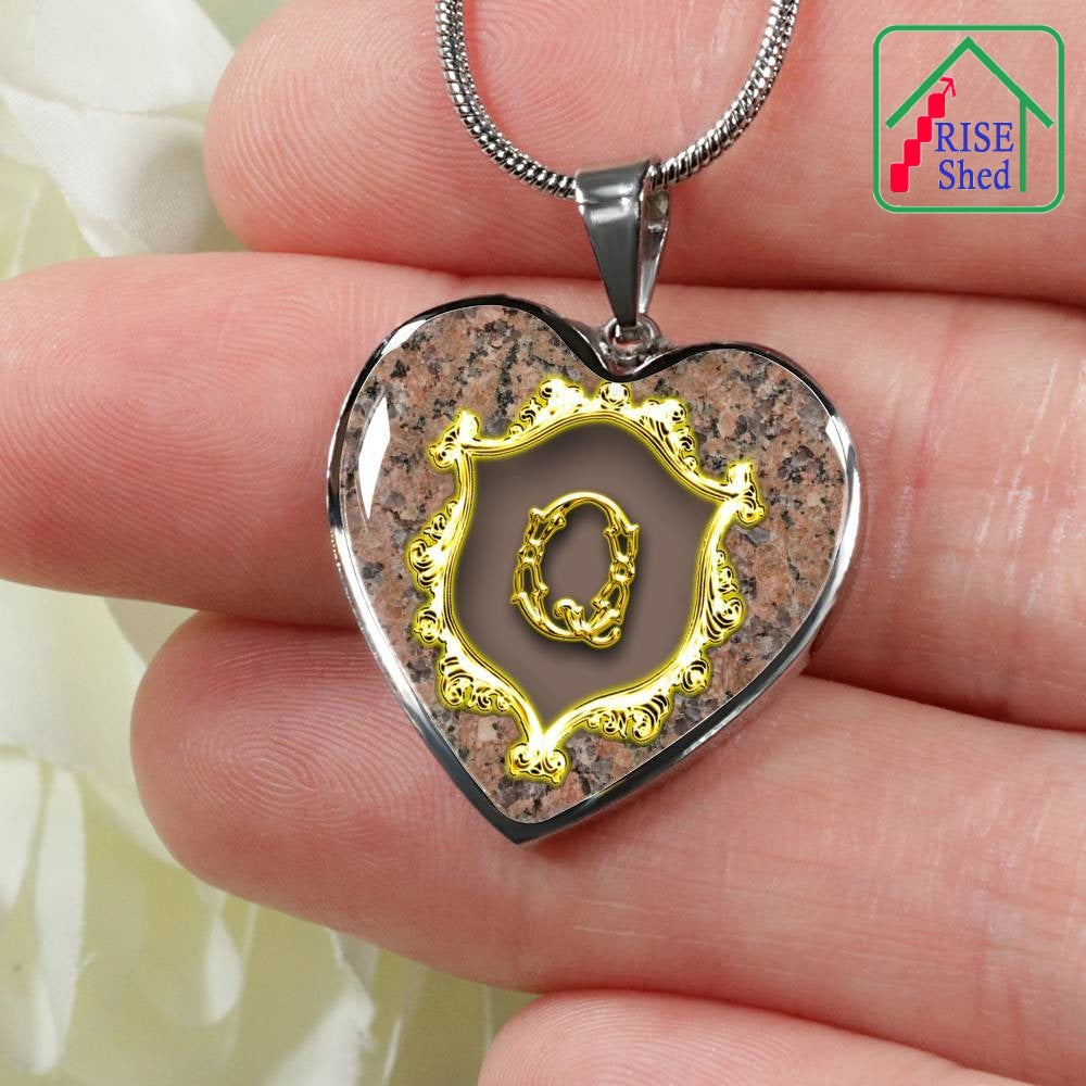 Close up Q Initial Monogram Alphabet Heart Pendant and Necklace being held in hand