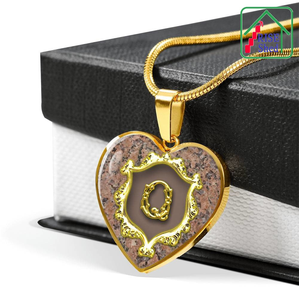 Q Initial Monogram Alphabet 18K Gold Finish Heart Pendant and Necklace draped over giftbox