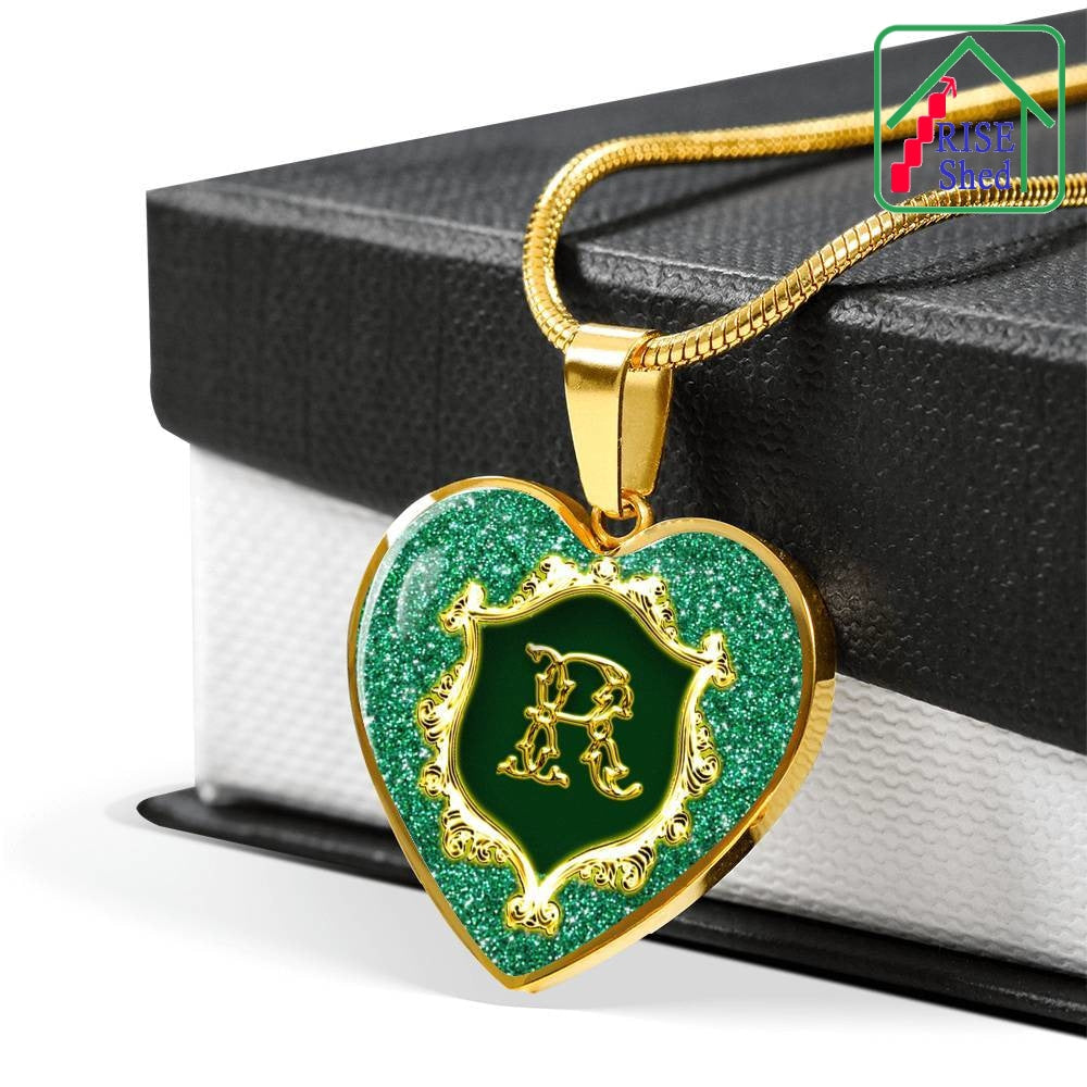 18K Gold Finish R Monogram Heart Pendant Alphabet Initial Necklace lays atop the black lid of giftbox