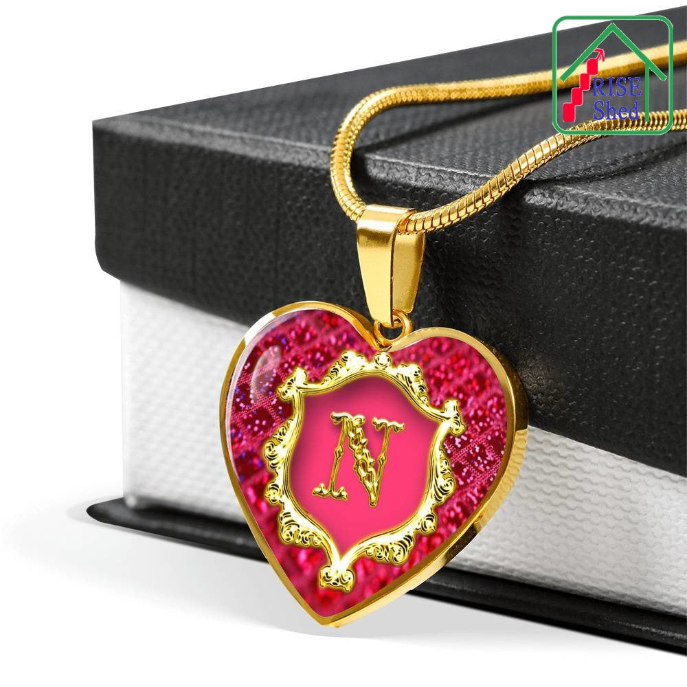 N Initial Monogram Alphabet 18K Gold Finish Heart Pendant and Necklace draped over giftbox