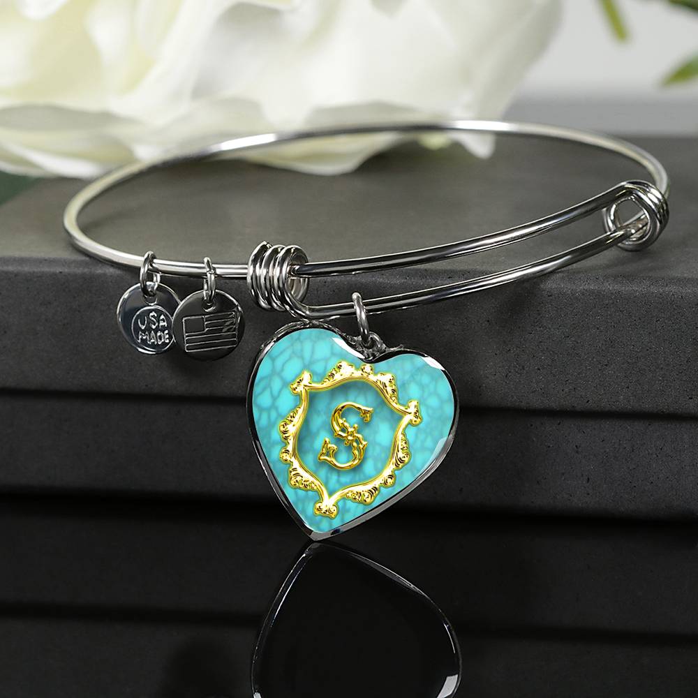 Heart Pendant Monogram S Alphabet Initial Bangle turquoise rests over a giftbox on a glass table