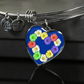 Daisy Chain Heart Pendant on a Stainless Steel Bangle sitting on top of giftbox atop glass table