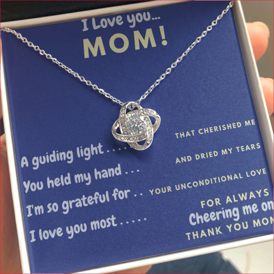 Cheering Mom CZ Love Knot Pendant sits inside Gift box with a greeting card style message which reads: I Love you...MOM! A guiding light... That cherished me, You held my hand... And dried my tears, I'm so grateful for... Your Unconditional Love, I love you most.... For Always Cheering me on, Thank You Mom.