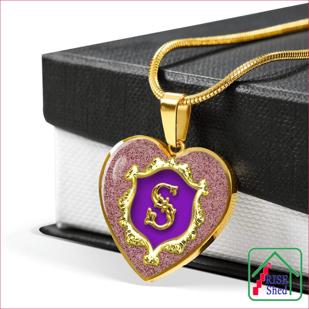 Letter S Monogrammed Heart necklace alphabet pendant with 18k gold finish lays across giftbox